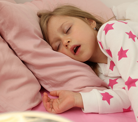 Young girl sleeping on her side with her mouth open