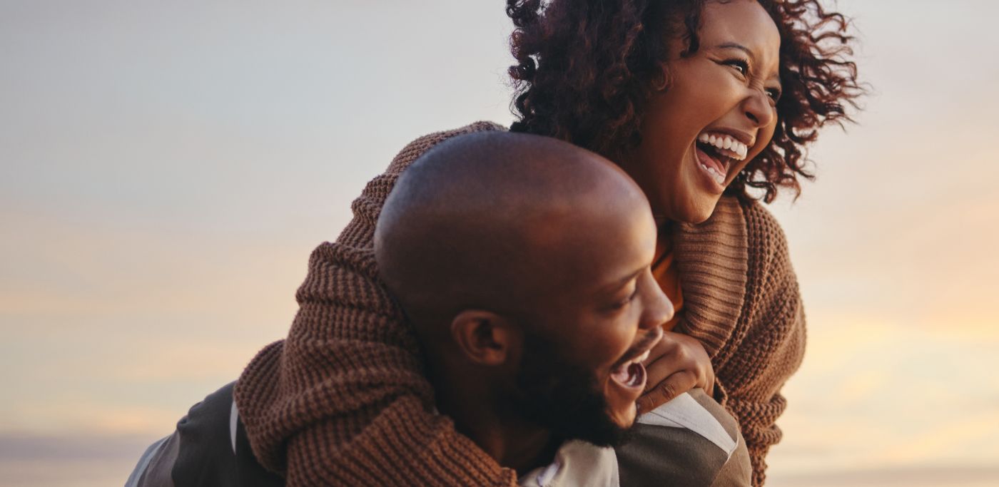 Man and woman laughing and embracing outdoors