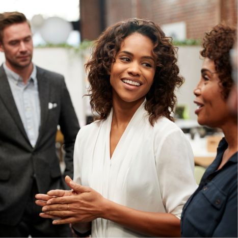 Three people in business attire having a discussion