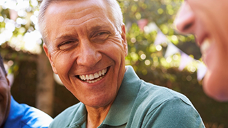 Three men laughing together in the sun