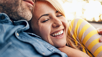 Woman laughing while she cuddles her man
